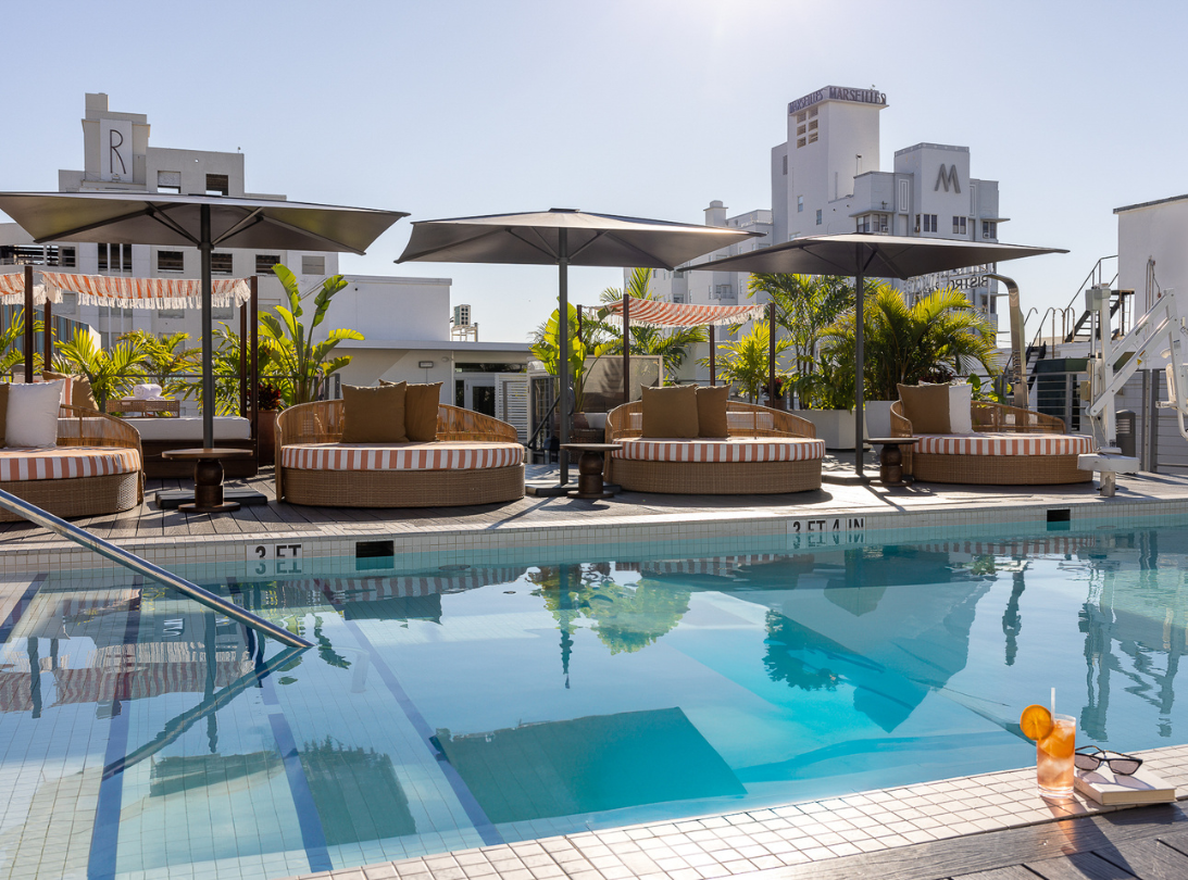 Imagen de la piscina en la terraza con 2 chicas en tumbonas rojas