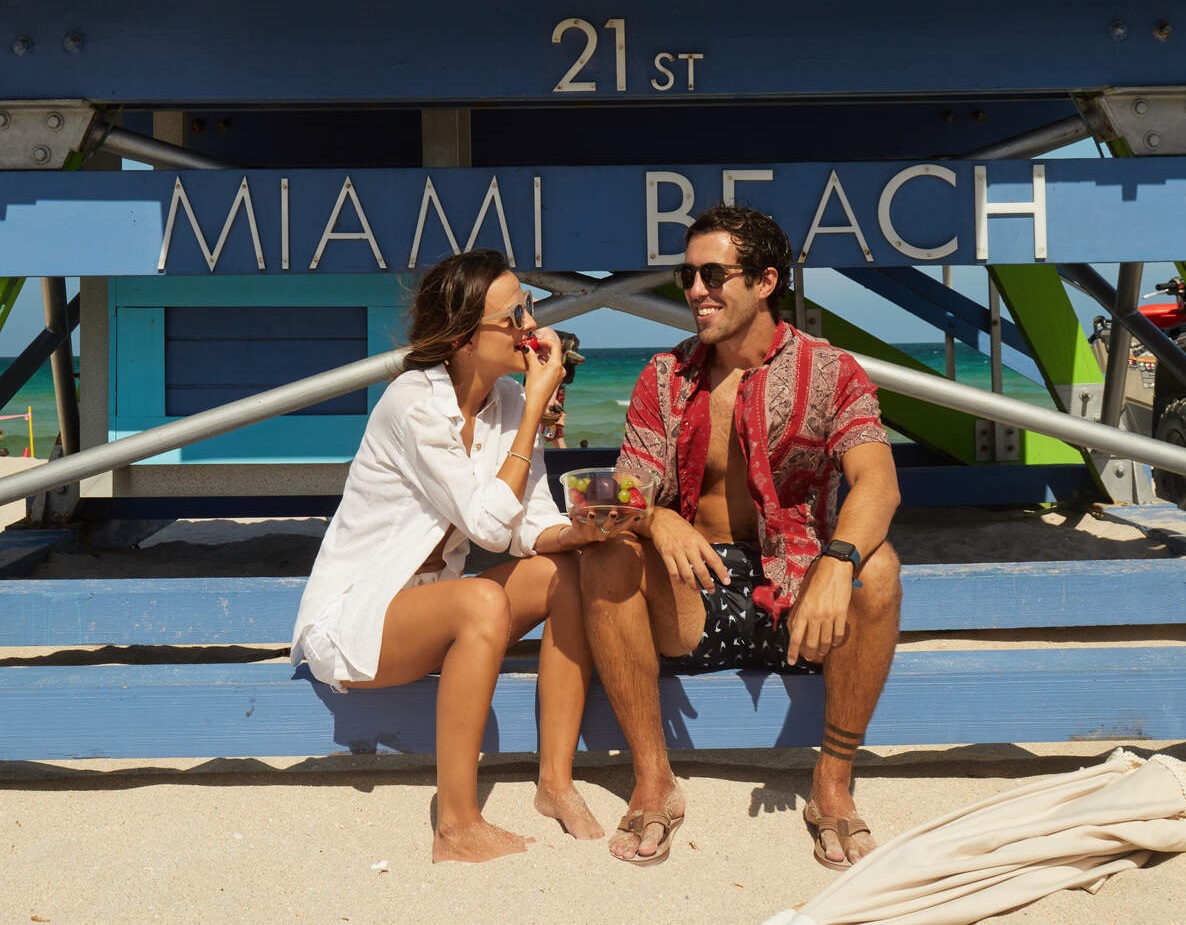 Pareja tomando dos copas de rosado en la piscina